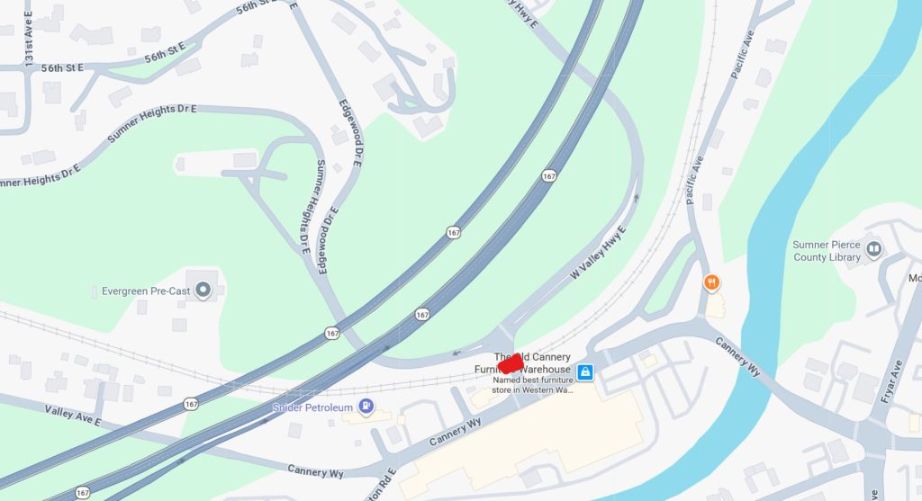 A street level map highlighting in red the location of the railroad track crossing that will be closed. It is situated south of Highway 167 (Valley Fwy) and W Valley Hwy E. Notable landmarks include Snider Petroleum to the west, Evergreen Pre-Cast to the northwest, and the Sumner Pierce County Library across the river to the east. The map shows the closed crossing adjacent to Cannery Wy.